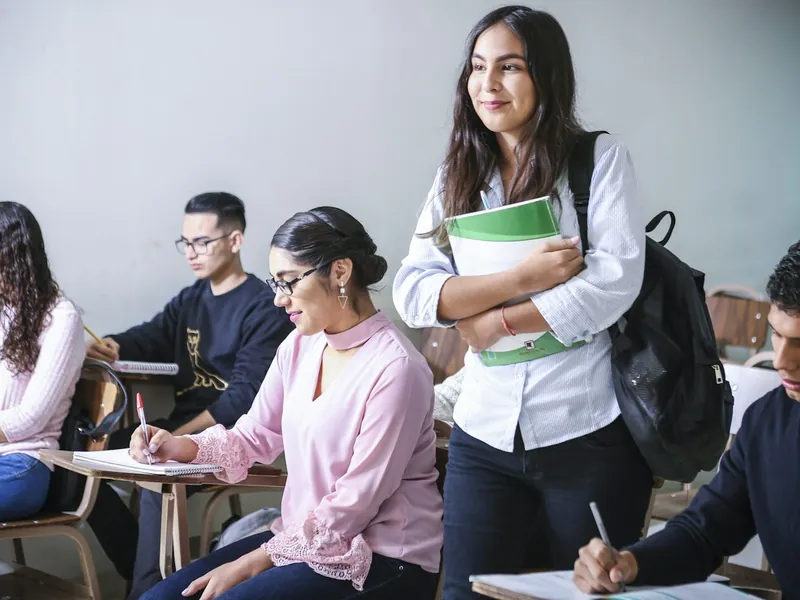 Estudiantes universitarios en clase con sus cuadernos